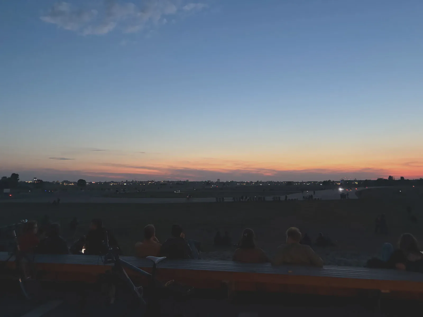 Flick auf das Rollfeld, welches mit menschenforderst, am Tempelhofer Flughafen zu später Stunde